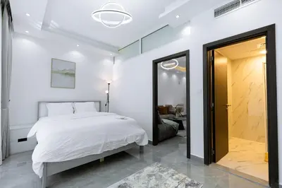 a bedroom with a white bed and a mirror at Dubai Marina - 1BHK Apartment near Dubai Metro in Dubai
