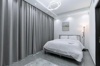 a bedroom with a bed and gray curtains at Dubai Marina - 1BHK Apartment near Dubai Metro in Dubai