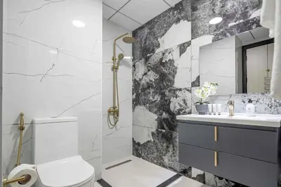 a bathroom with a black and white marble wall at Frank Porter - Skyz By Danube in Dubai