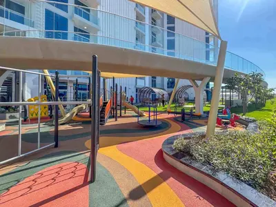 a playground in front of a large building at Frank Porter - Skyz By Danube in Dubai