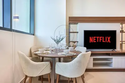 a dining room with a table with chairs and a tv at Binghatti Royale premium 1BR with Jacuzzi in Dubai