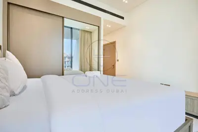 a bedroom with a white bed and a large window at Binghatti Royale premium 1BR with Jacuzzi in Dubai