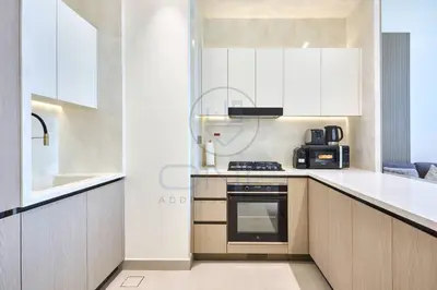 a kitchen with white cabinets and a stove top oven at Binghatti Royale premium 1BR with Jacuzzi in Dubai