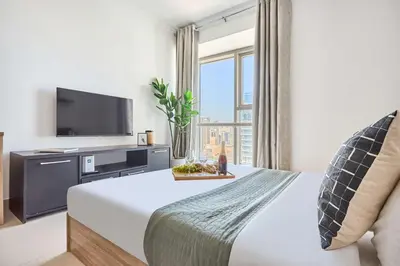 a hotel room with a bed and a flat screen tv at Frank Porter - Goldcrest Executive in Dubai