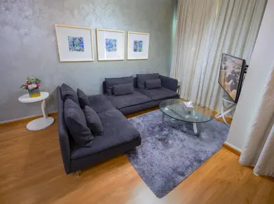 a living room with a couch and a glass table at Damac Downtown 1 BHK apartment with Burj Khalifa view in Dubai