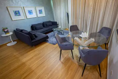 a living room with a glass table and chairs at Damac Downtown 1 BHK apartment with Burj Khalifa view in Dubai