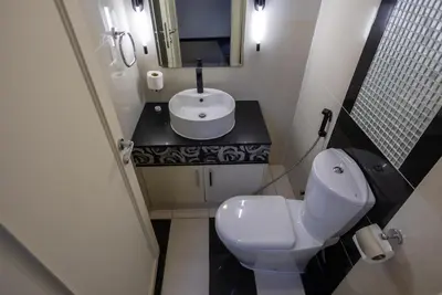 a bathroom with a white toilet and a sink at Damac Downtown 1 BHK apartment with Burj Khalifa view in Dubai