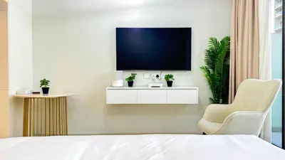 a bedroom with a bed and a tv on a wall at High floor studio with stunning views in Aykon City in Dubai