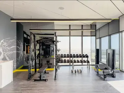 a gym with rows of exercise equipment in a room at High floor studio with stunning views in Aykon City in Dubai