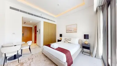 a bedroom with a bed and a desk and a table at Luxurious Chic Comfort Studio in Dubai