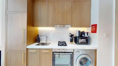 a kitchen with a sink and a washing machine at Luxurious Chic Comfort Studio in Dubai