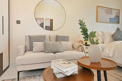 a living room with a couch and a round mirror at Bloomfields Stunning STU, Elz By Danube, Dubai in Dubai