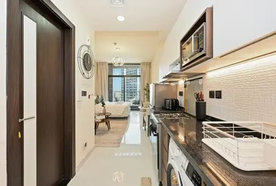 a kitchen with a counter top and a living room at Bloomfields Stunning STU, Elz By Danube, Dubai in Dubai
