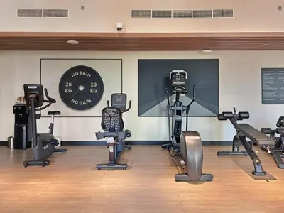 a gym with cardio equipment and a clock on the wall at Serene Creek Harbour Escape with Burj Khalifa View in Dubai