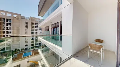 a glass balcony with a chair in a building at Modern Furnished Studio Azizi Riviera in Dubai