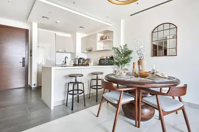 a kitchen and dining room with a wooden table and chairs at Frank Porter - The Crest Tower, Sobha Hartland in Dubai