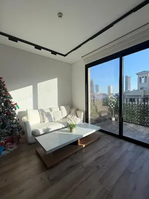 a living room with a couch and a christmas tree at Lux 2 Bedroom Cozy Family Getaway Home in Dubai