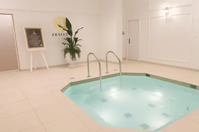 a large swimming pool in a room with a sign at Luxury Apartment in Vincitore Benessere, Dubai in Dubai