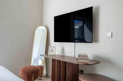 a living room with a tv on a wall at Frank Porter - Avenue Residence in Dubai