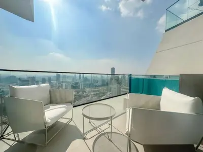 a balcony with two chairs and a table on a building at Modern and Cozy 1 Bedroom with Private Balcony Pool in Dubai