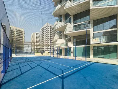 an empty tennis court in front of a building at Modern and Cozy 1 Bedroom with Private Balcony Pool in Dubai