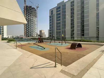 a playground in a city with tall buildings at Modern and Cozy 1 Bedroom with Private Balcony Pool in Dubai