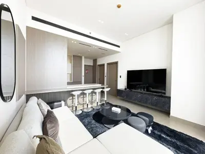 a living room with a couch and a table at Modern and Cozy 1 Bedroom with Private Balcony Pool in Dubai
