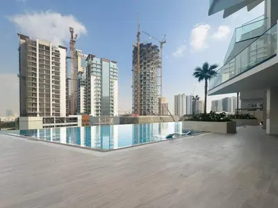 a swimming pool in the middle of a city with tall buildings at Modern and Cozy 1 Bedroom with Private Balcony Pool in Dubai