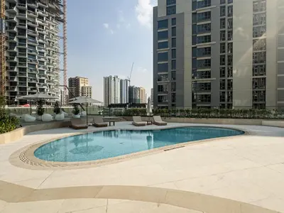 a swimming pool in the middle of a city with tall buildings at Modern and Cozy 1 Bedroom with Private Balcony Pool in Dubai