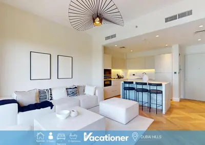 a living room with a white couch and a kitchen at Vacationer l Upgraded Aesthetic 2 Bed l near Dubai Hills Mall in Dubai
