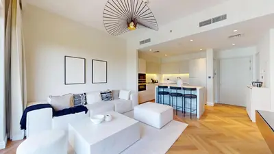 a living room with white furniture and a kitchen at Vacationer l Upgraded Aesthetic 2 Bed l near Dubai Hills Mall in Dubai