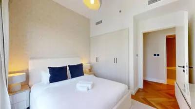a bedroom with a white bed with blue pillows at Vacationer l Upgraded Aesthetic 2 Bed l near Dubai Hills Mall in Dubai