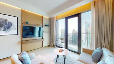 a living room with a tv and large windows at Vacationer l Elegant 2 Bed l near Burj Khalifa l Address Opera in Dubai