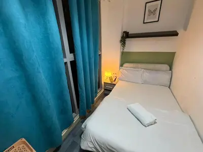 a bedroom with a bed and a window with blue curtains at Modren Private Partition Room In Barsha Heights Tecom in Dubai