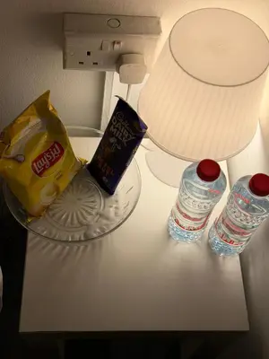 a counter with a bottle of water and a bag of chips at Quiet Comfort Room In Barsha Heights Tecom in Dubai
