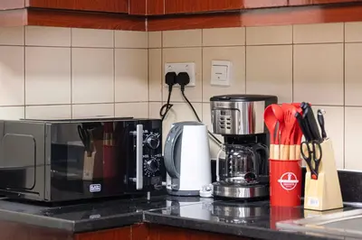 a kitchen counter with a coffee maker and a microwave at Luxe 4BR Upscale Beach Side Unit with Pool Table in Dubai