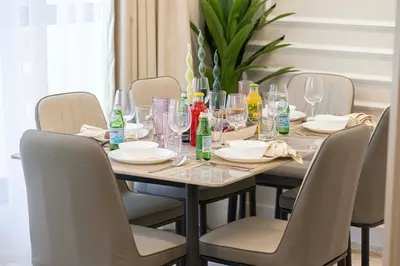 a dining room table with chairs and wine glasses on it at Chic JBR Apartment Beach Walk Dining Nightlife in Dubai