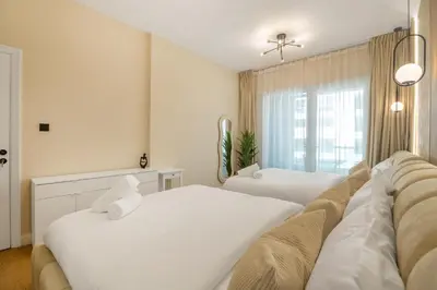 a bedroom with two white beds and a window at Lux condo 3 BHK in Dubai Marina in Dubai