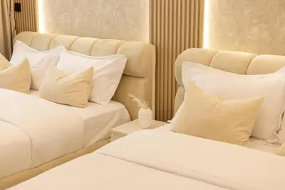 two beds with white sheets and pillows in a room at Lux condo 3 BHK in Dubai Marina in Dubai