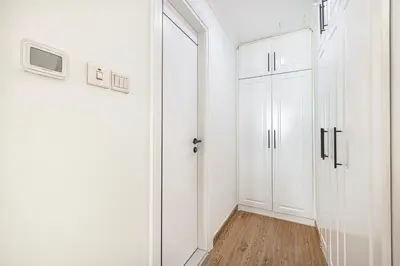 a white hallway with a door and a tv at Luxury 3BHK with floating bed in Marina in Dubai