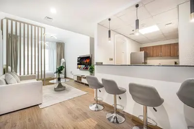 a kitchen and living room with a counter and chairs at Luxury 3BHK with floating bed in Marina in Dubai