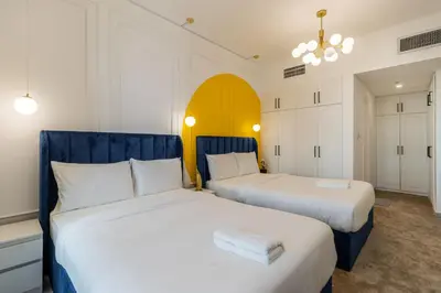 two beds in a room with white and blue at Luxury 3BR & Floating Bed in Marina with Pool in Dubai