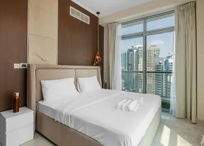 a bedroom with a white bed with a large window at Lux 3BHK With Pvt Jacuzzi in Marina in Dubai