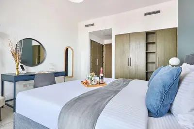 a bedroom with a large white bed and a mirror at Frank Porter - Loft Tower West in Dubai
