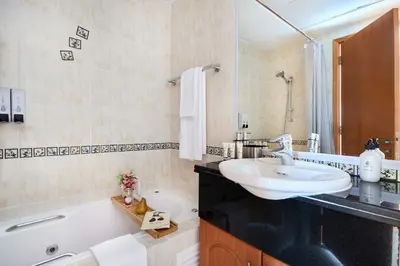 a bathroom with a sink and a bath tub at Frank Porter - Damac Waves Tower, Dubai Marina in Dubai