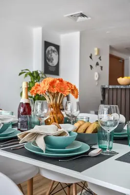 a dining room table with plates and glasses on it at Frank Porter - Damac Waves Tower, Dubai Marina in Dubai
