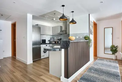 a kitchen with white cabinets and a counter top at Frank Porter - Damac Waves Tower, Dubai Marina in Dubai