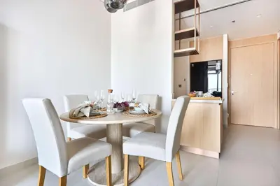 a dining room with a table and white chairs at Frank Porter - Vida Dubai Mall in Dubai
