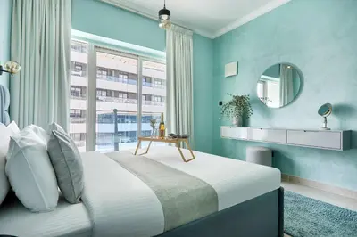 a bedroom with a bed with a mirror and a window at Frank Porter - Opal Tower in Dubai