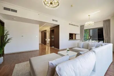 a living room with a white couch and a chandelier at Lux Unit Breathtaking Burj View I Walk Dubai Mall in Dubai
